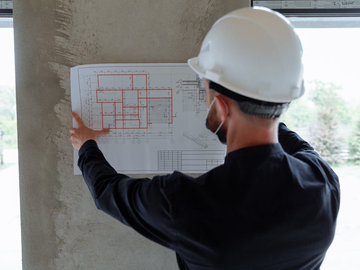 Engenheiro analisando projeto técnico em obra